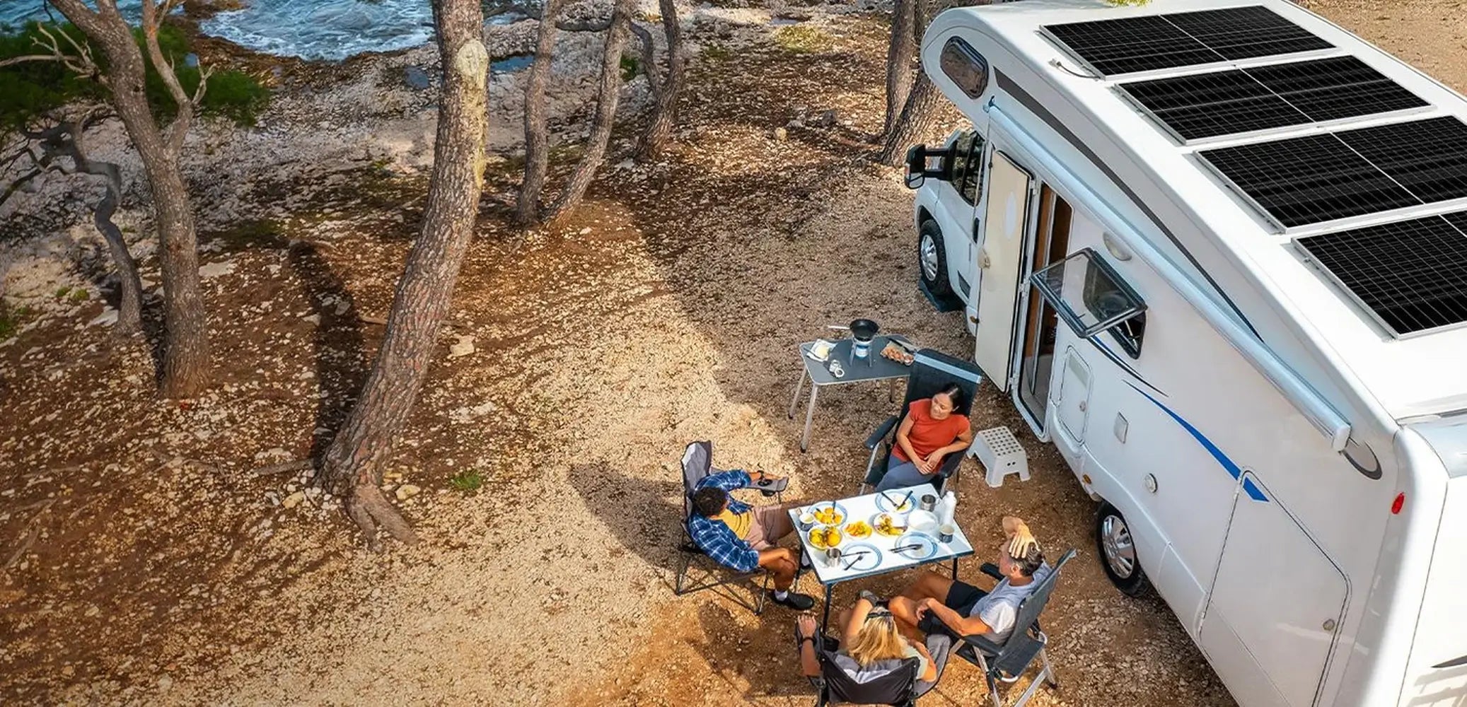 Overhead lifestyle view of campers relaxing next to a motorhome equipped with a roof-mounted Rich Solar 335W solar panel array.