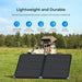 Renogy lightweight and durable portable solar suitcase deployed in a grassy field with an overlanding camping truck.