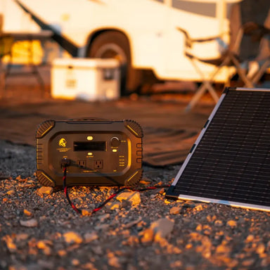 Lion Energy Summit portable power station charging from a solar panel at a campsite with the 25-foot solar extension cable connected for off-grid power use