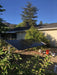 Ground-mounted solar array featuring three Rich Solar 335W all-black solar panels in a residential backyard setup.