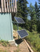 Overhead view of a DIY camper van solar setup showing two rigid panels integrated onto a black modular roof rack platform deck.