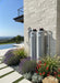 Professional outdoor installation of the AlkaViva Grande UltraHome Salt-Free Whole House Water Filter system against a stone wall in a modern landscape.
