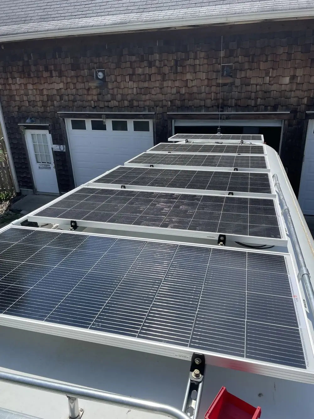 Off-grid RV solar panel installation featuring multiple Rich Solar panels mounted flat on the roof of a camper van conversion.