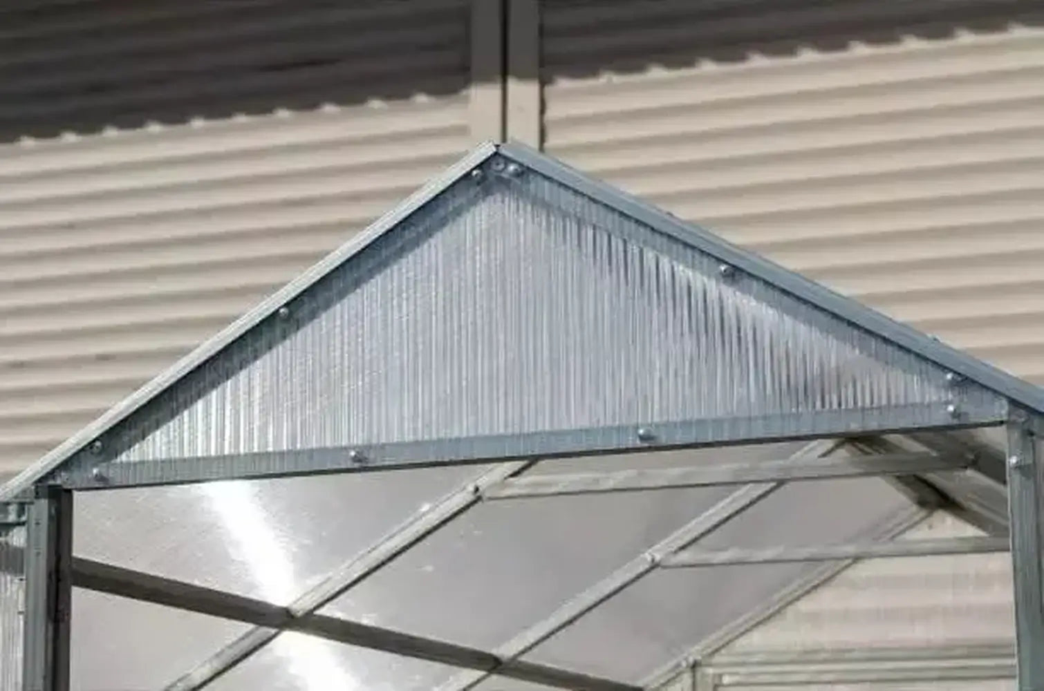 Close-up detail of the gable roof peak and galvanized steel hardware on the Daisy Greenhouse Kit.