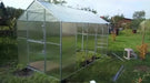 Exterior view of a GreenhouseToGrow Daisy 8.3'x26' Greenhouse during the final stages of installation on a grass lawn.