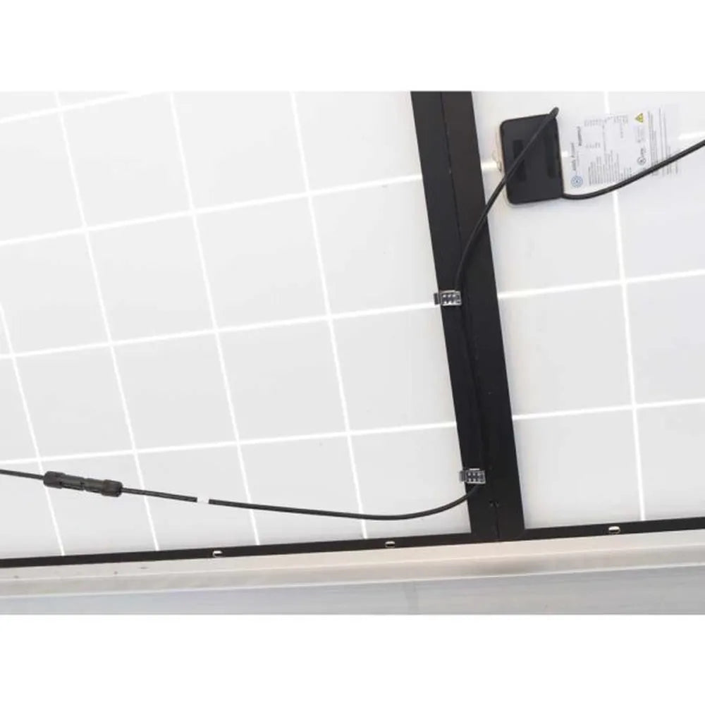 Rear view of a solar panel showing black PV wires organized with small metal cable clamps near the junction box and MC4-style connector lead.