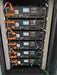 Close-up of six Rich Solar Alpha 5 Pro 5.12kWh lithium server rack batteries wired together in parallel inside a cabinet.