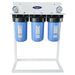 Triple stage Crystal Quest SMART Compact whole house filtration system on a white floor stand with dual gauges for easy pressure monitoring.