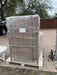 Side profile view of a large freight pallet containing a shrink-wrapped Rich Solar server rack cabinet box during residential delivery.